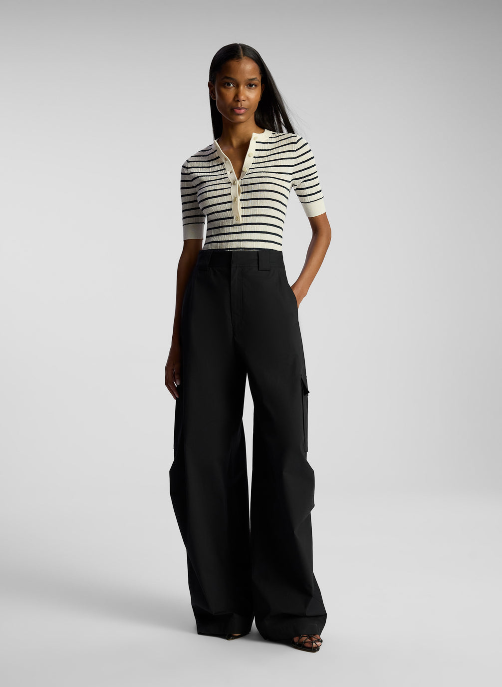 front view of woman wearing striped top and black cargo pants