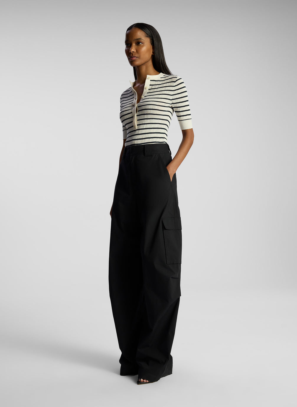 side view of woman wearing striped top and black cargo pants
