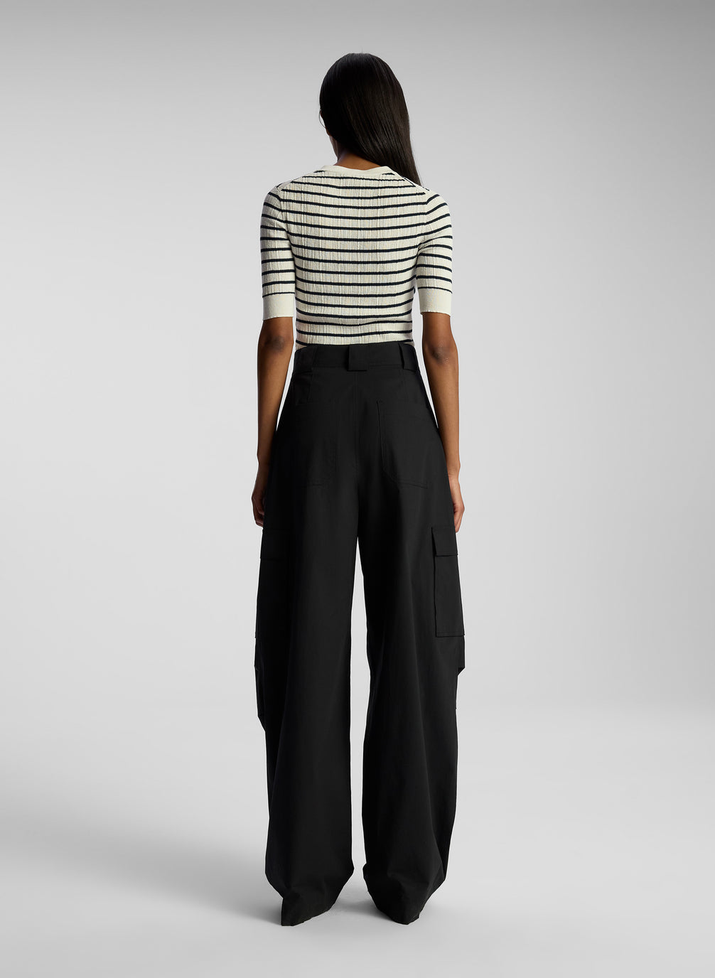 back view of woman wearing striped top and black cargo pants