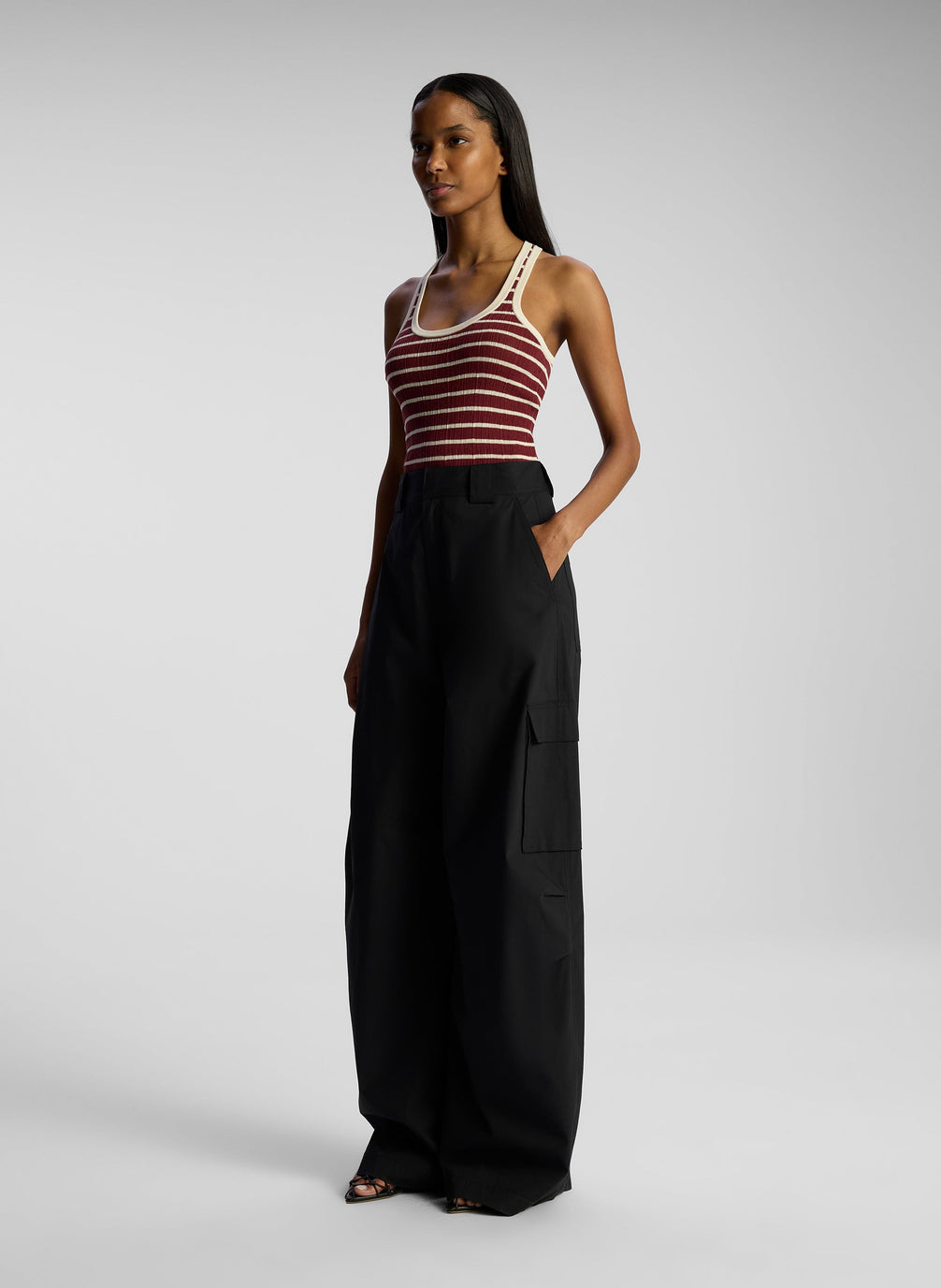 side view of woman wearing burgundy striped tank top and black cargo pants