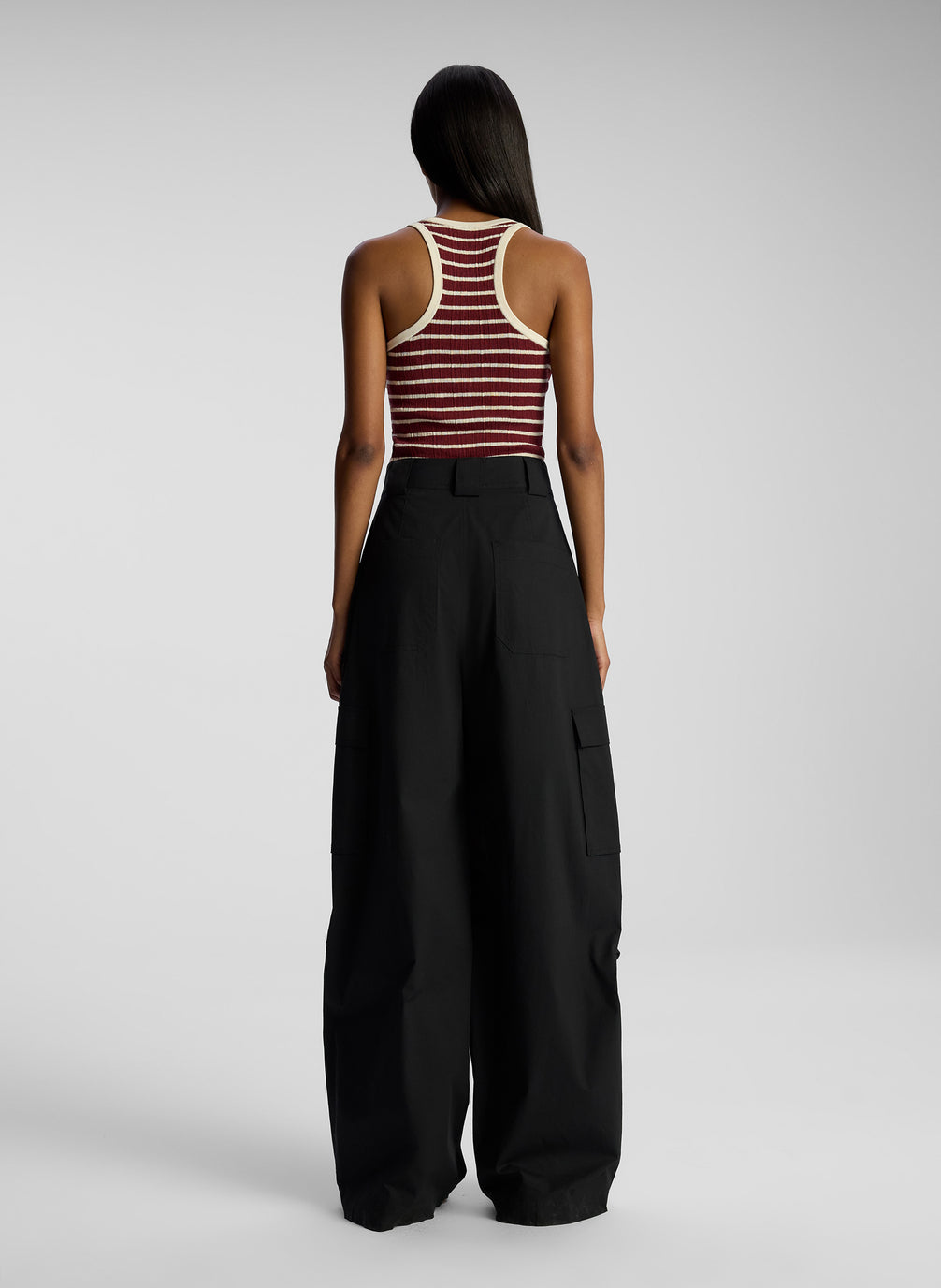 back view of woman wearing burgundy striped tank top and black cargo pants