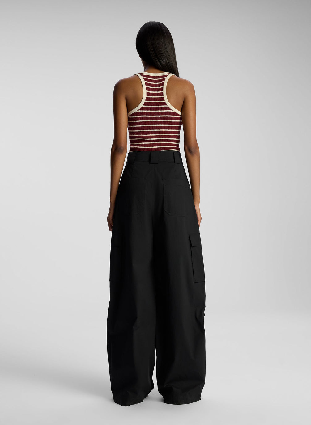 back view of woman wearing burgundy striped tank top and black cargo pants