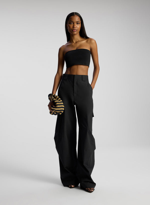 front view of woman wearing black strapless crop top and black pants