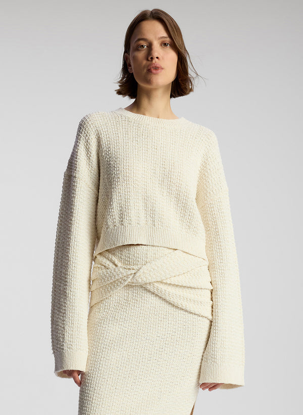 front view of woman wearing white pullover sweater and matching midi skirt