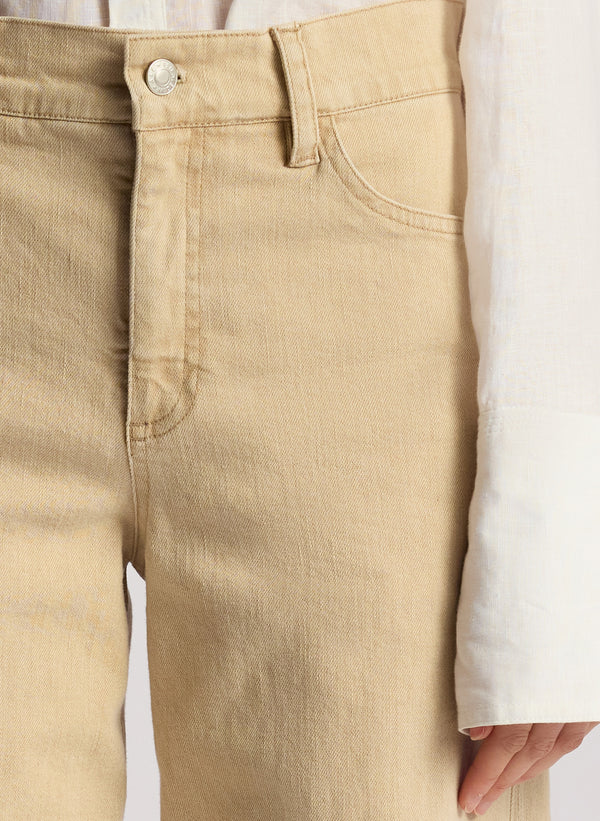 detail view of woman wearing white button down shirt and tan pants