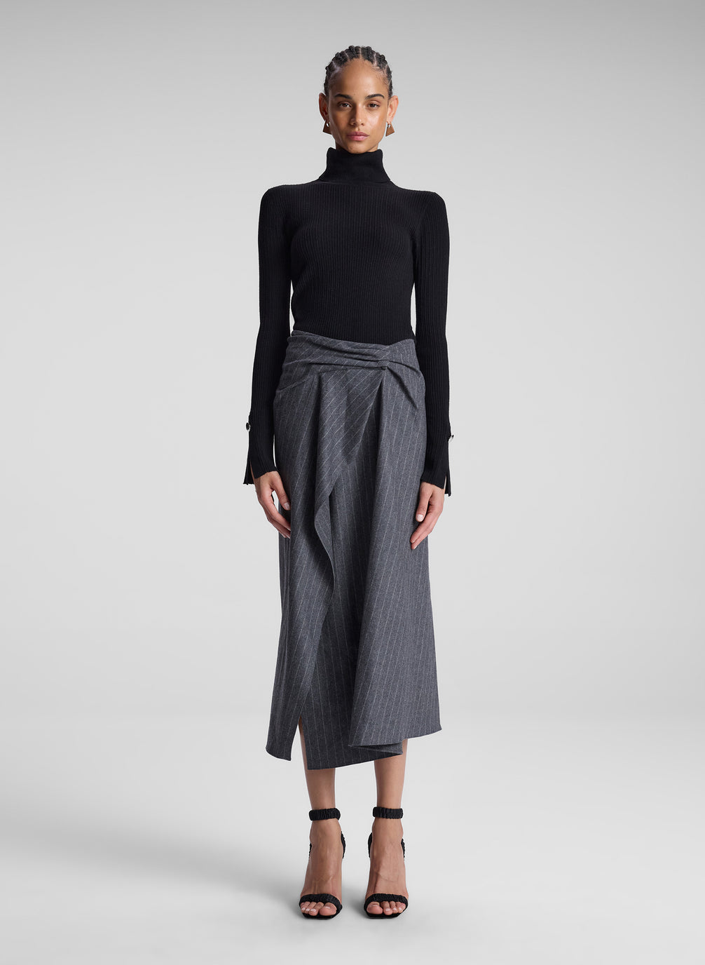 woman wearing black turtleneck and grey pinstriped midi skirt