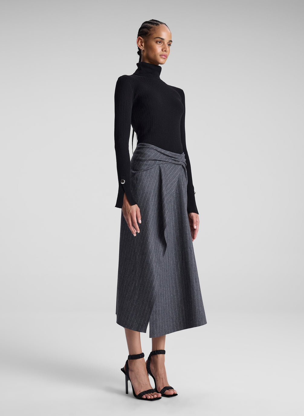 woman wearing black turtleneck and grey pinstriped midi skirt