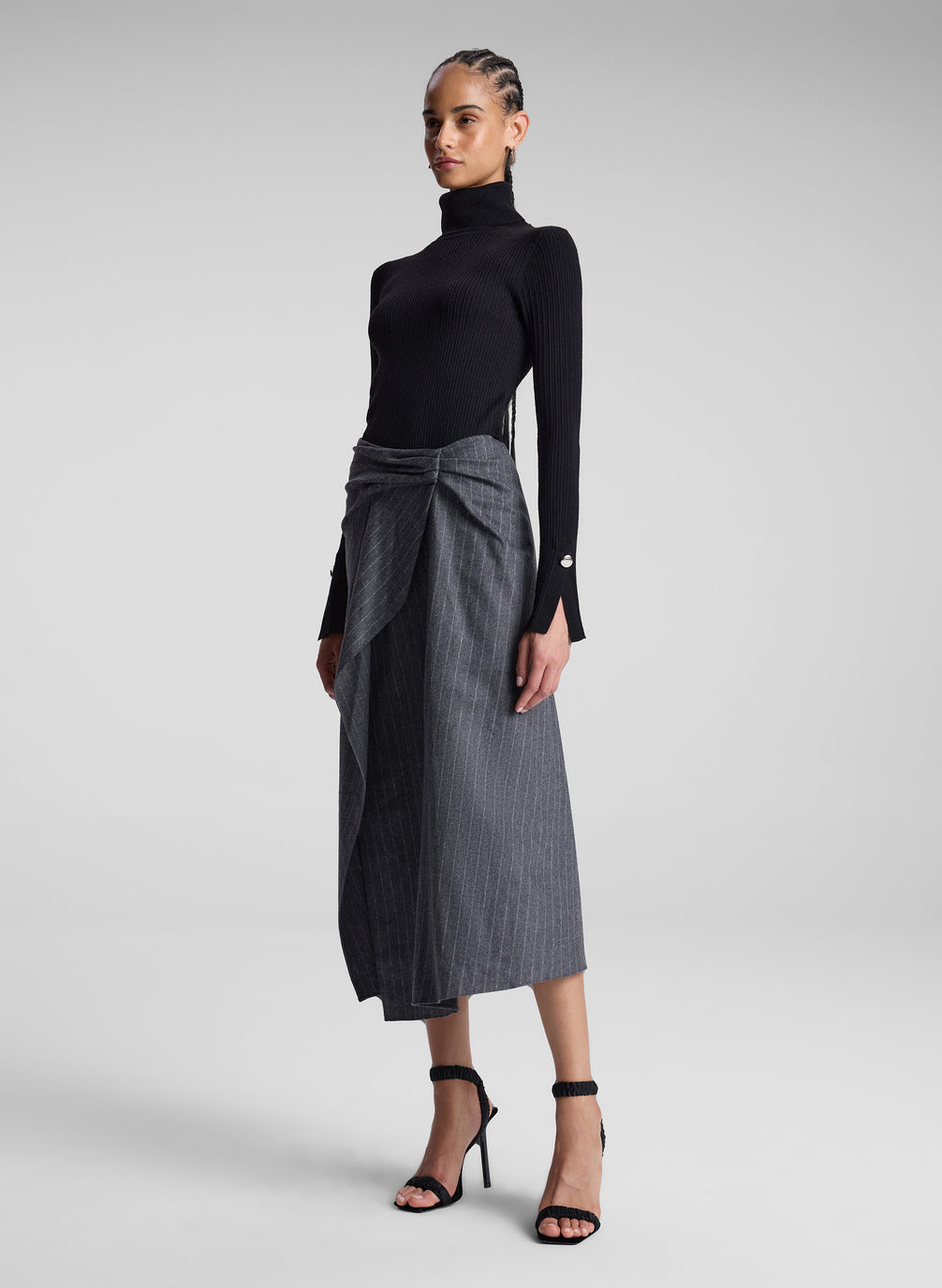 woman wearing black turtleneck and grey pinstriped midi skirt