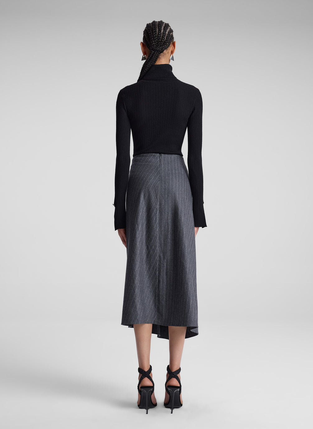 woman wearing black turtleneck and grey pinstriped midi skirt