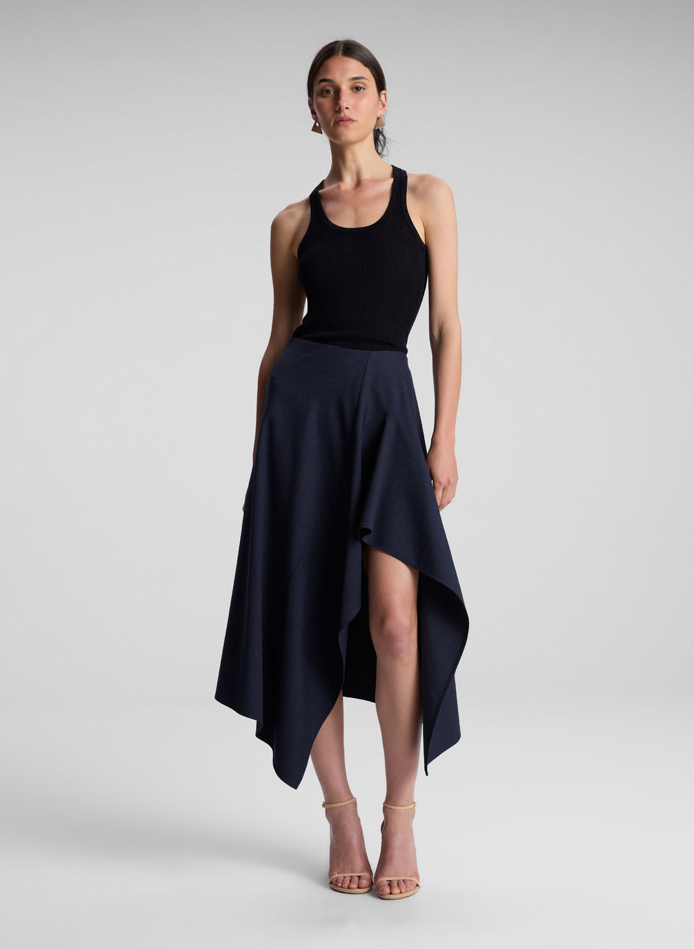 woman wearing black tank top with navy and black skirt