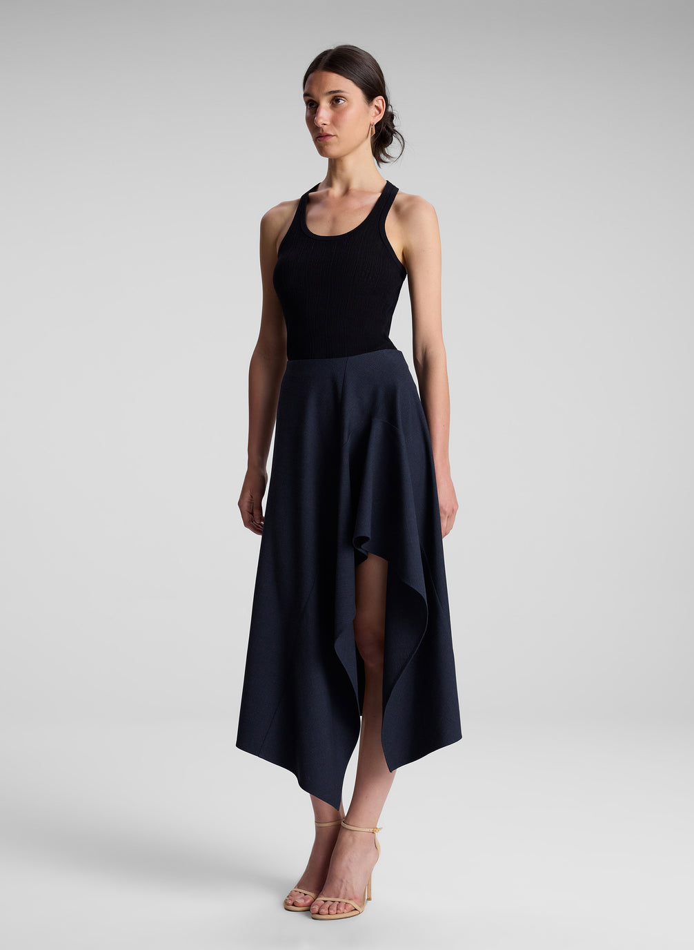 woman wearing black tank top with navy and black skirt