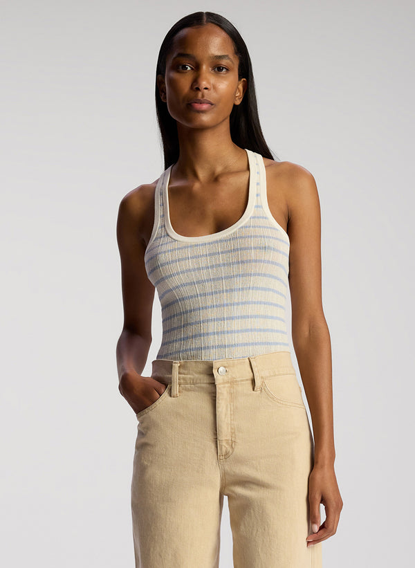 front view of woman wearing light blue and white striped tank top and tan pants