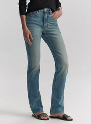 Woman wearing a navy blue shirt and blue jeans on a white background