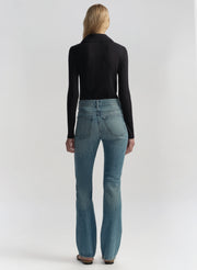 Woman wearing a navy blue shirt and blue jeans on a white background