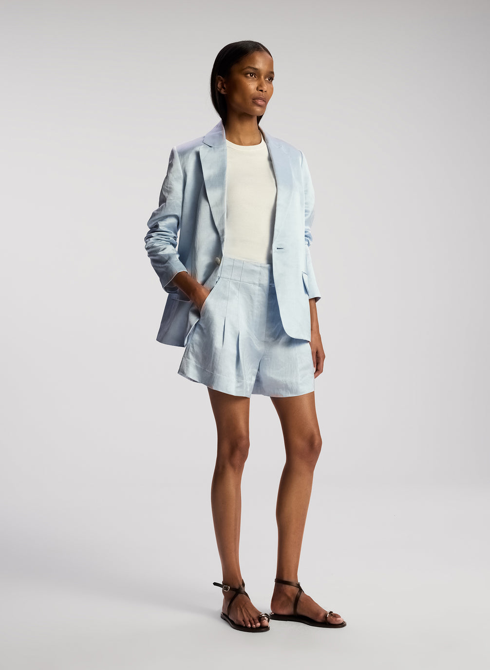 side view of woman wearing light blue blazer with matching shorts