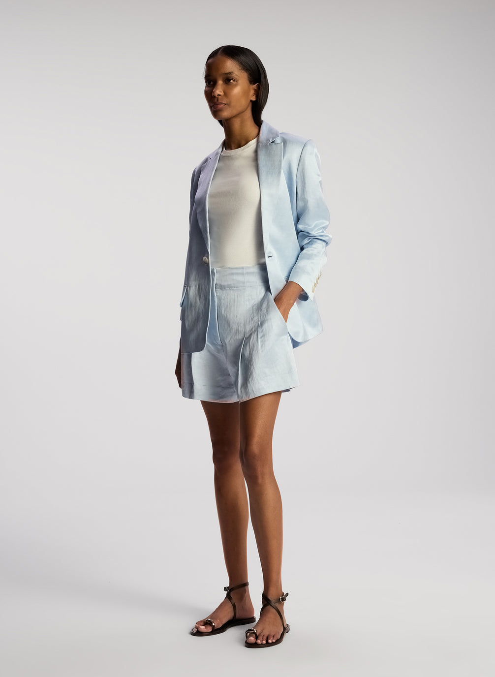 side view of woman wearing light blue blazer with matching shorts