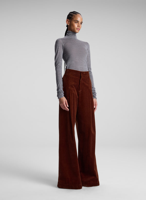 woman wearing grey turtleneck and maroon corduroy  pants