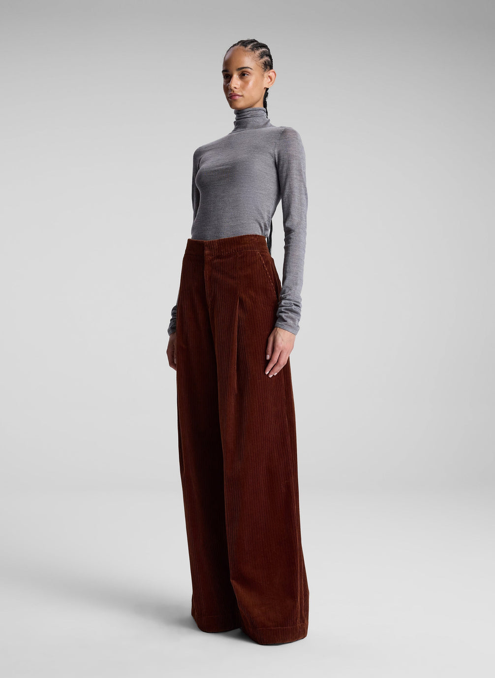 woman wearing grey turtleneck and maroon corduroy pants