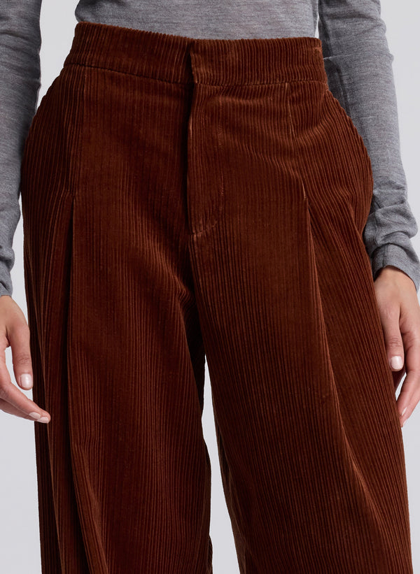 woman wearing grey turtleneck and maroon corduroy pants