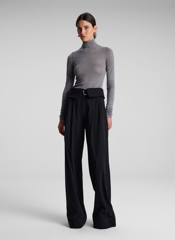 woman wearing grey turtleneck and black pants