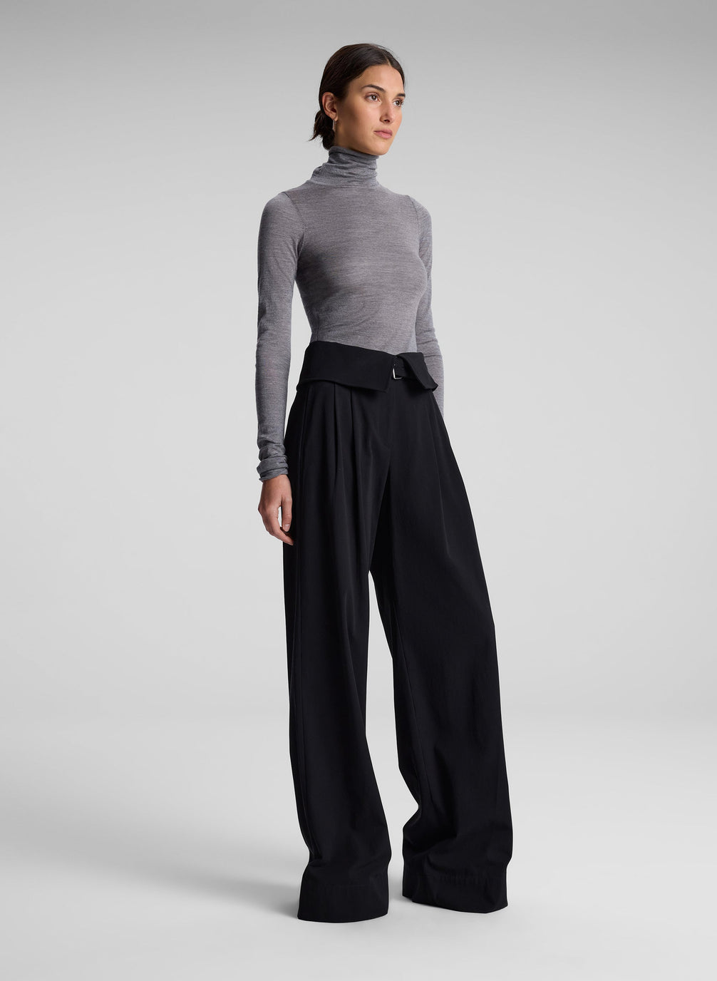 woman wearing grey turtleneck and black pants