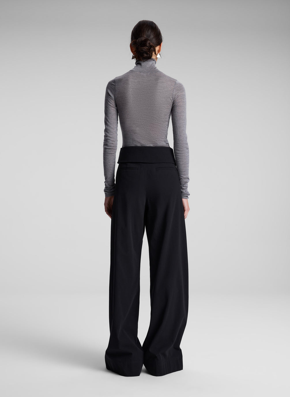 woman wearing grey turtleneck and black pants