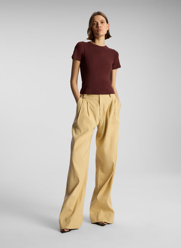 front view of woman wearing brown t shirt and tan pants