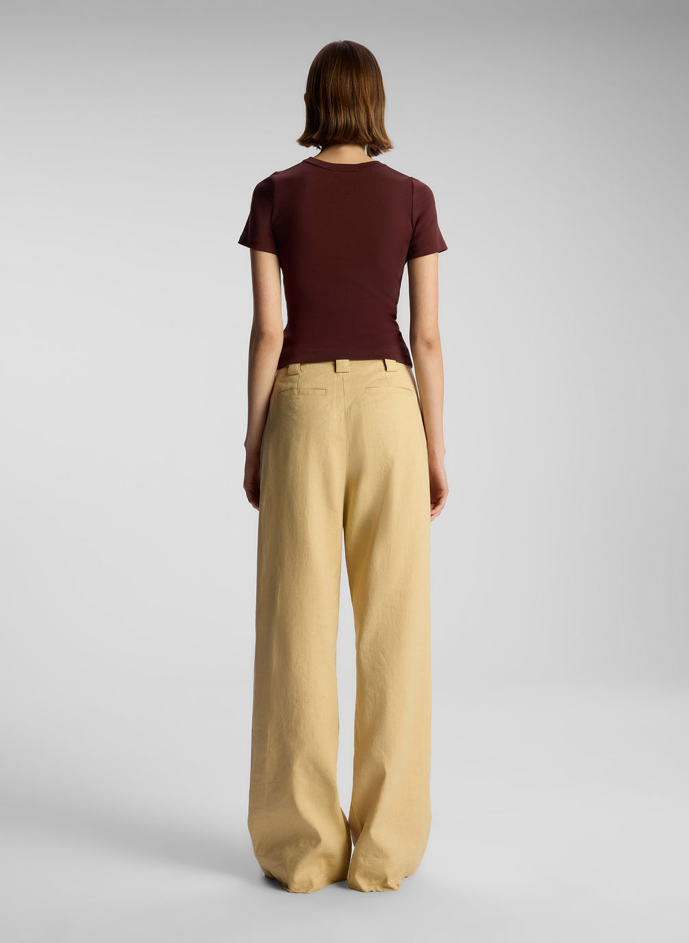 back view of woman wearing brown t shirt and tan pants