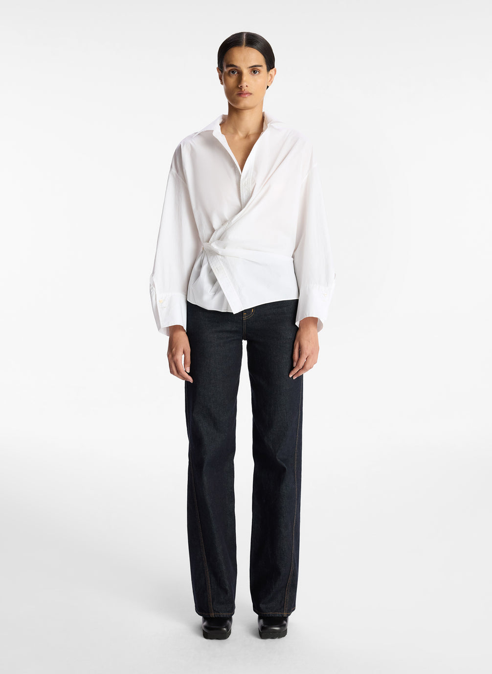 front view of woman wearing white collared cotton wrap top and dark wash denim jeans