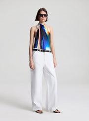 woman wearing multicolor halterneck top and white pants