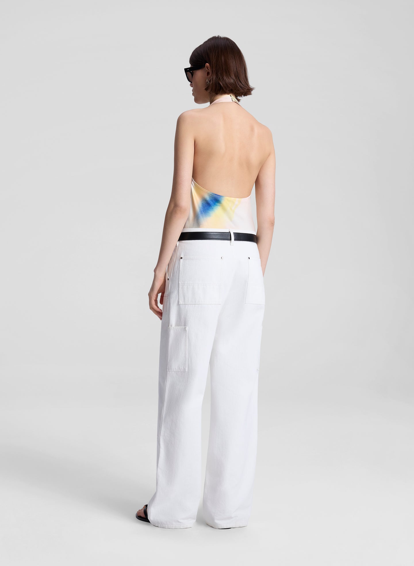 woman wearing multicolor halterneck top and white pants