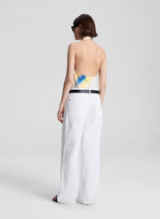 woman wearing multicolor halterneck top and white pants