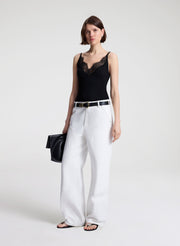 woman wearing black lace camisole and white denim jeans