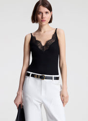 woman wearing black lace camisole and white denim jeans