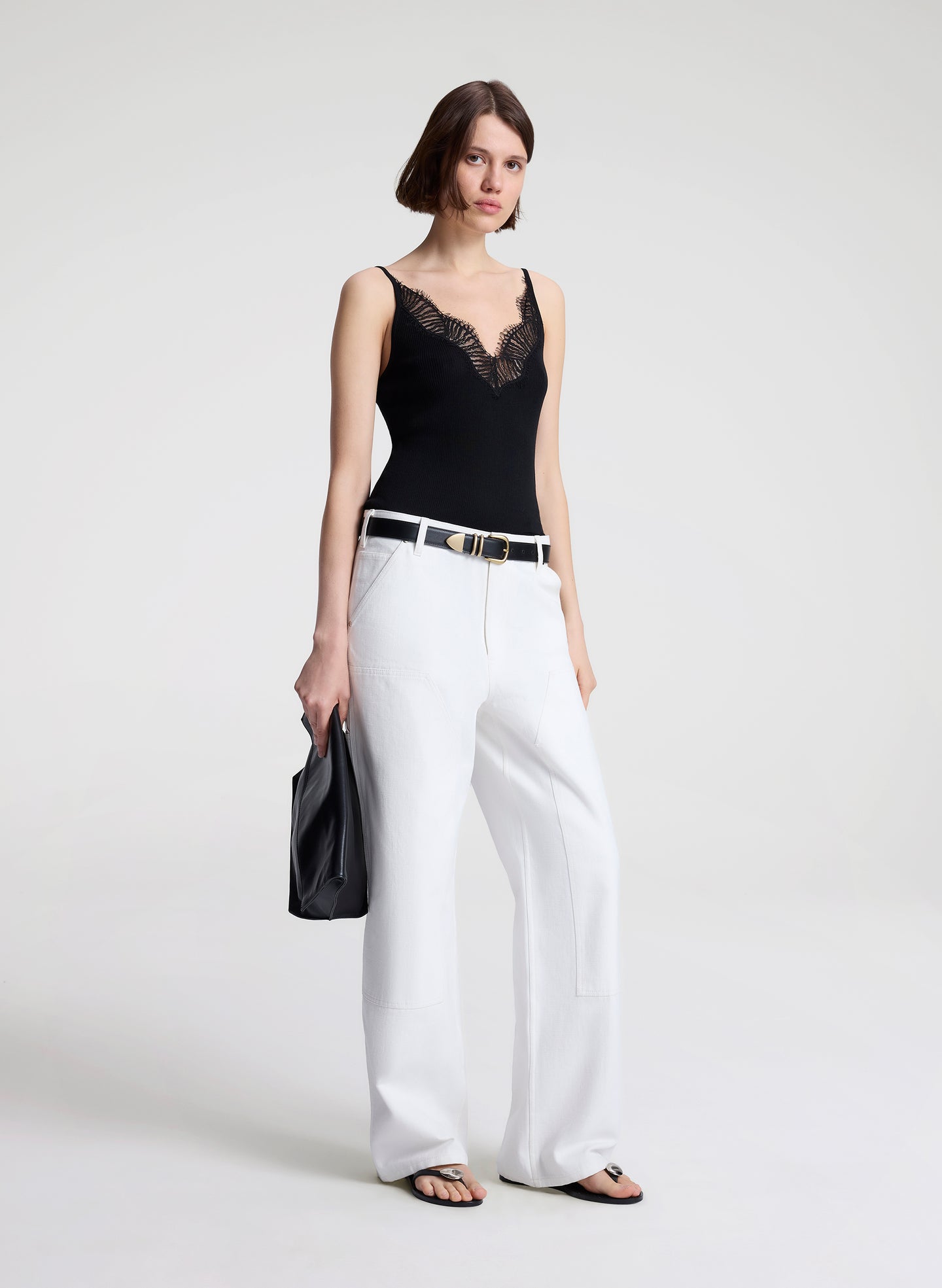 woman wearing black lace camisole and white denim jeans