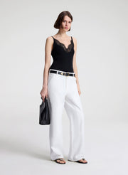 woman wearing black lace camisole and white denim jeans