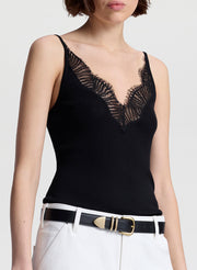 woman wearing black lace camisole and white denim jeans