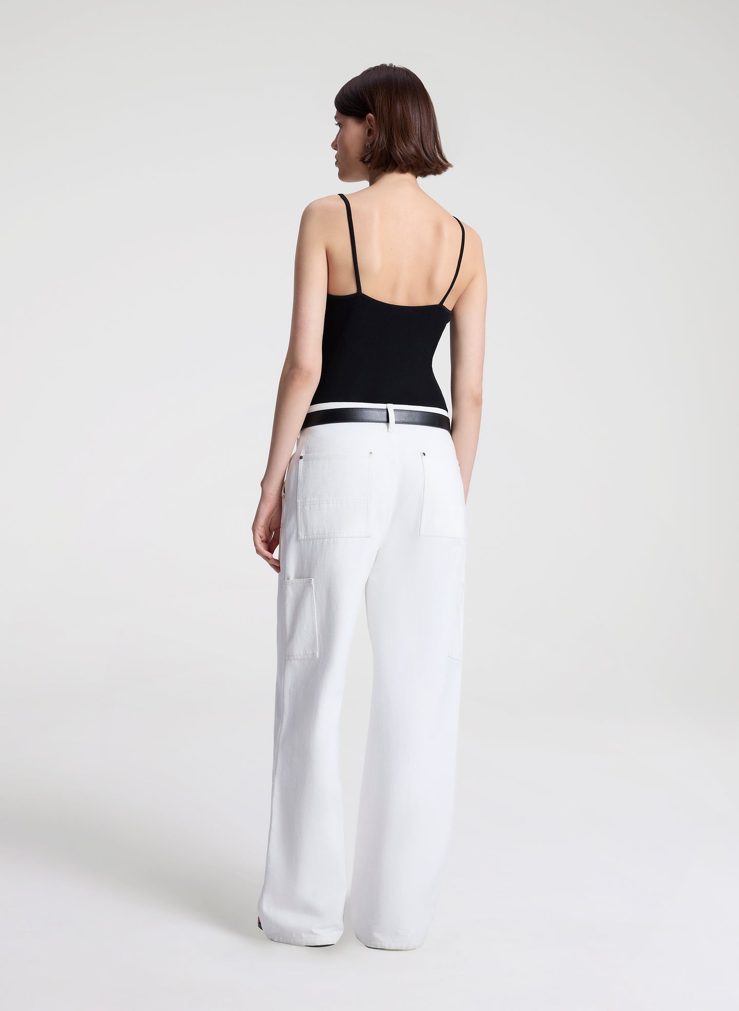 woman wearing black lace camisole and white denim jeans