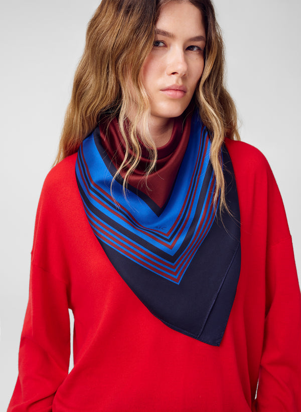 woman wearing silk scarf and red sweater