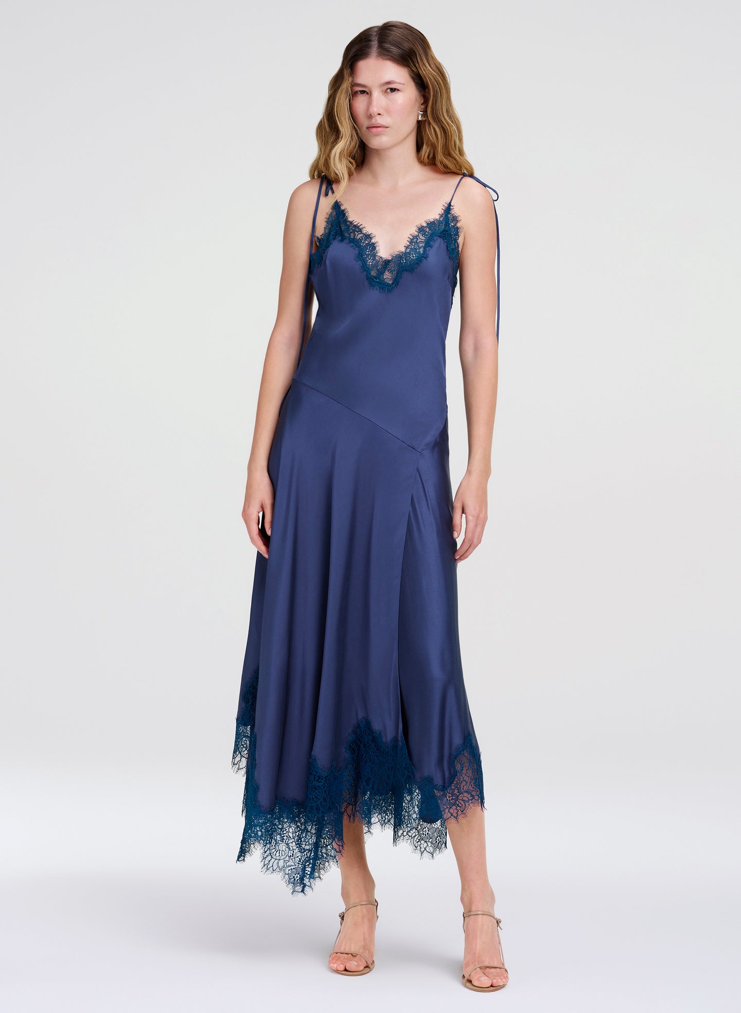 Woman wearing a blue lace dress on a white background