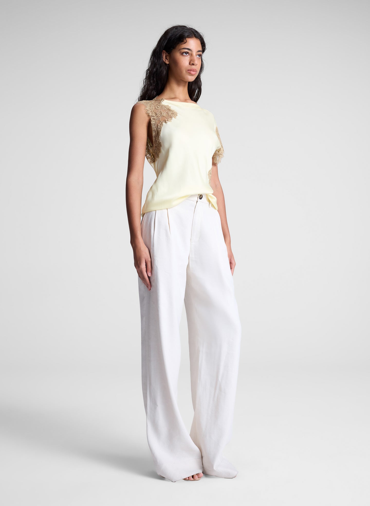 woman wearing butter yellow satin and lace top and cream wide leg pants