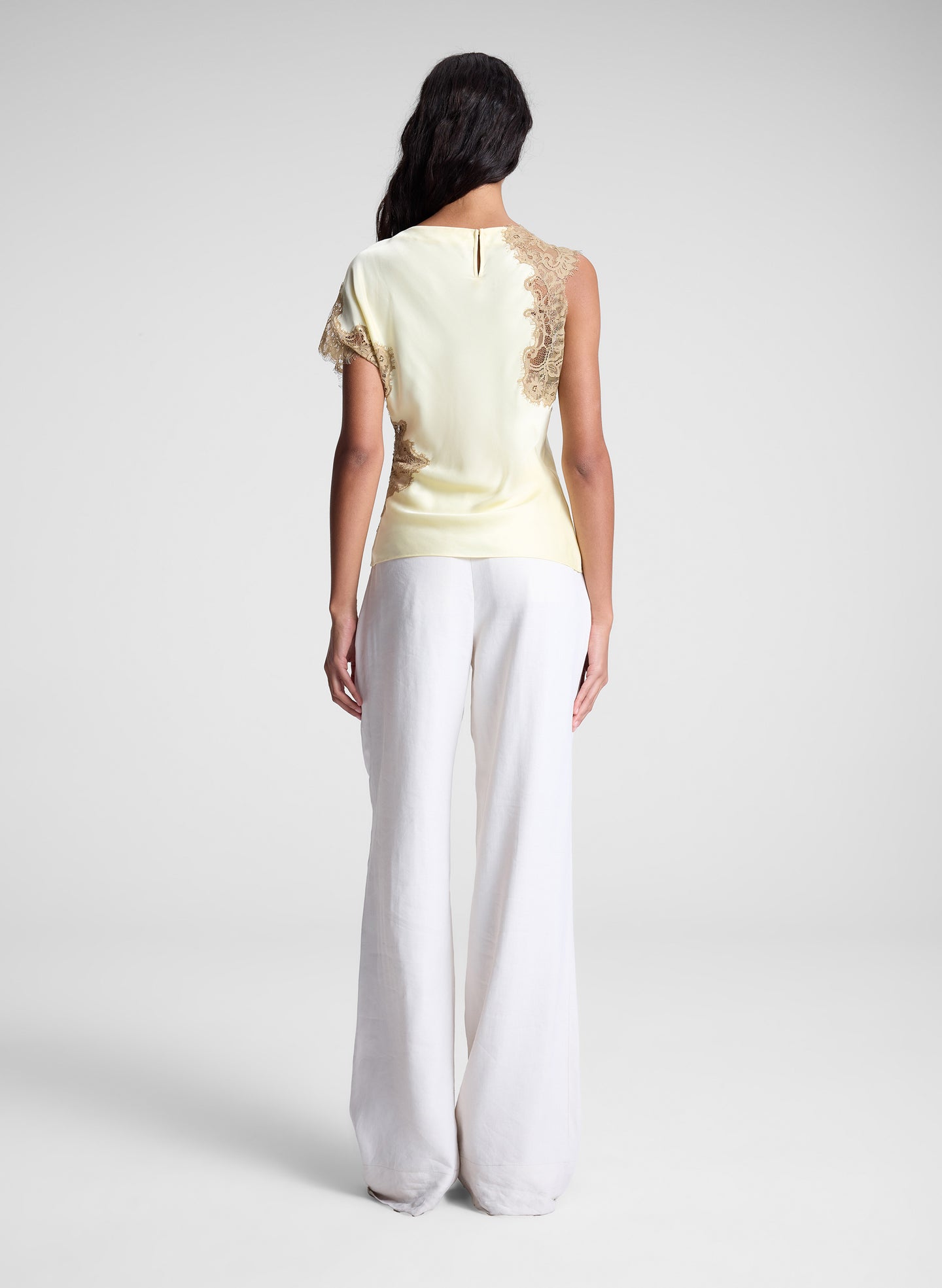 woman wearing butter yellow satin and lace top and cream wide leg pants