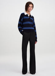 woman wearing blue striped polo sweater and black pants