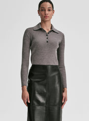 Woman wearing a gray shirt and black leather skirt on a light gray background