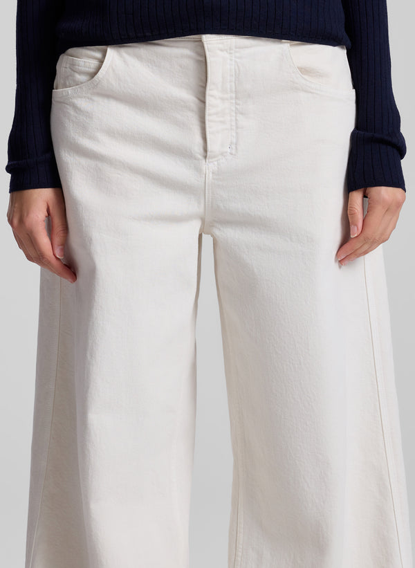 woman wearing navy blue top and white denim pants