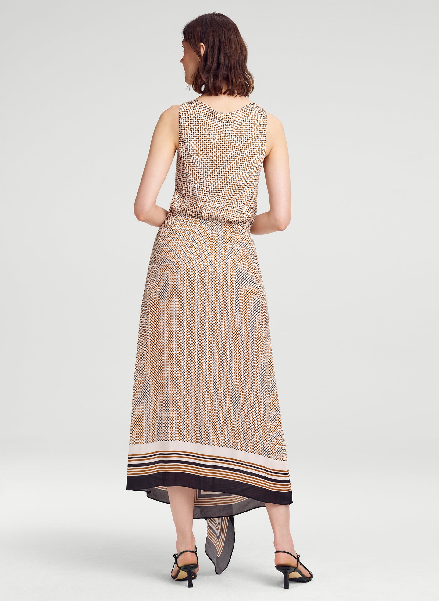 Woman wearing a patterned dress on a white background