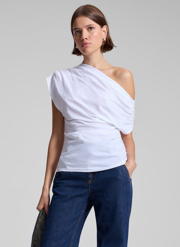 woman wearing white off the shoulder t shirt and medium wash denim