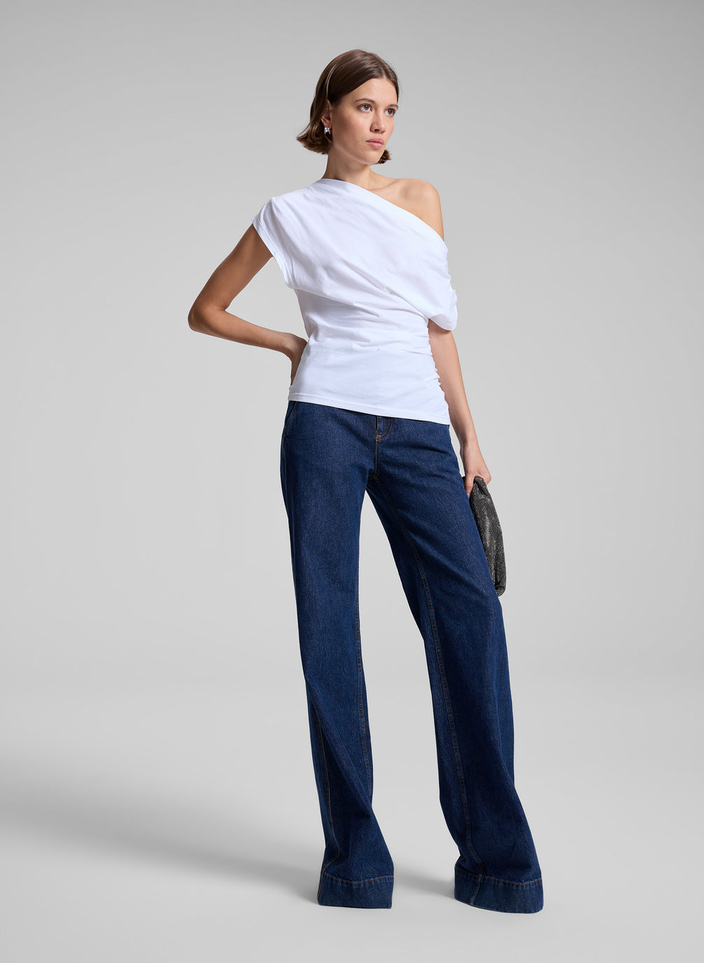 woman wearing white off the shoulder t shirt and medium wash denim