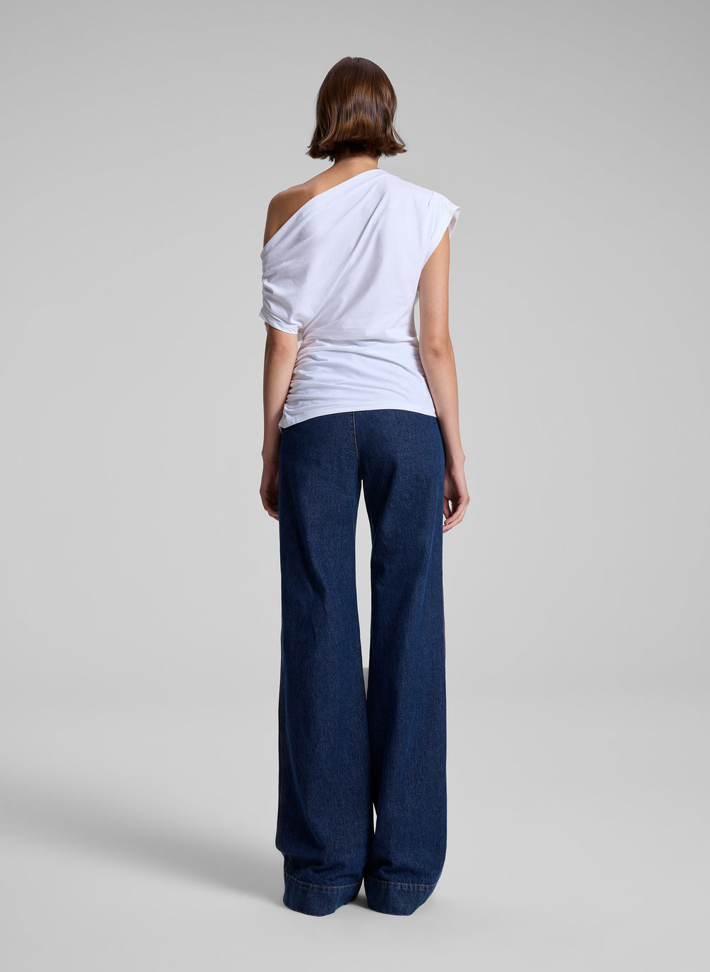 woman wearing white off the shoulder t shirt and medium wash denim