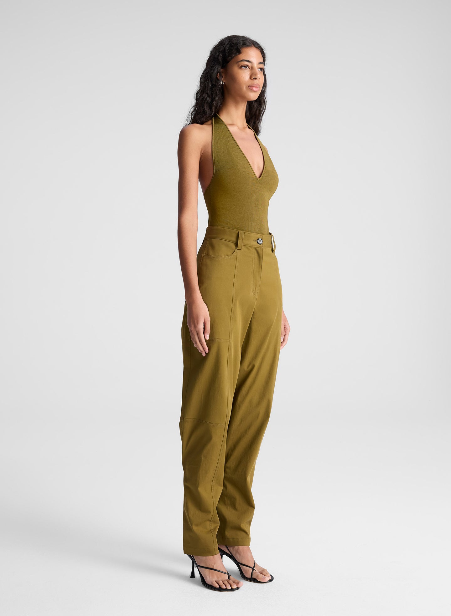 woman wearing green bodysuit and green pants